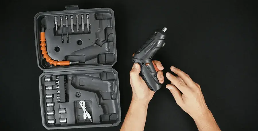 Hands holding the driver next to the open case.